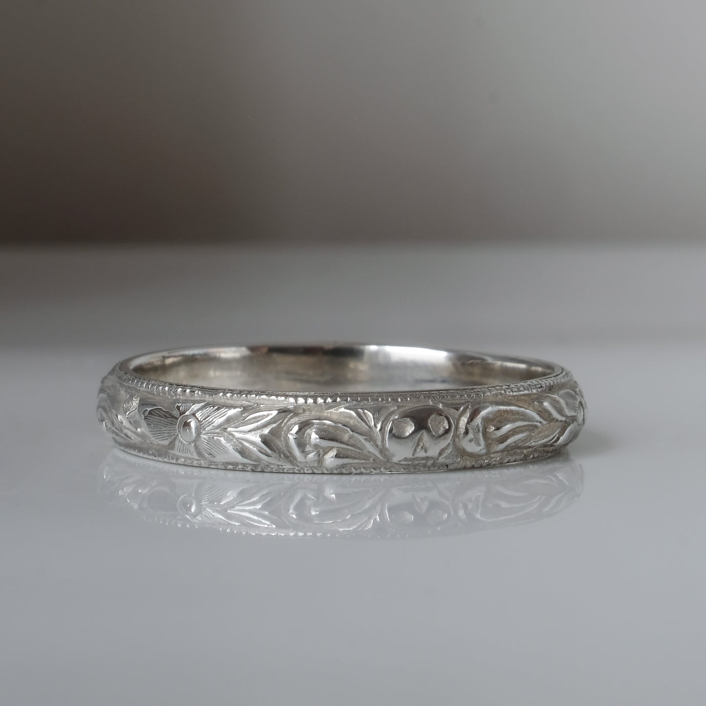 Silver band engraved with skulls, flourishes and flowers by Charlie Shires