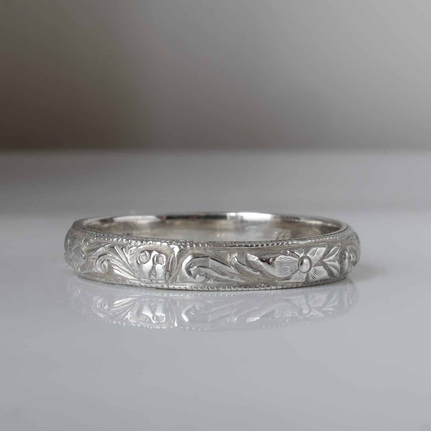 Silver band engraved with skulls, flourishes and flowers by Charlie Shires