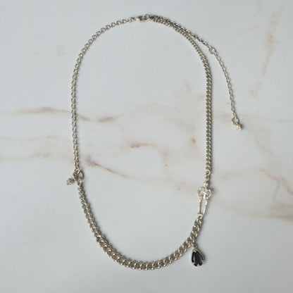 Sterling silver curb link necklace with skeleton and hanging moonstone. Photographed on white background. Made in London by Charlie Shires