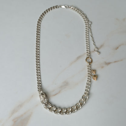 Heavy weight sterling silver curb link chain descending in size. 9ct yellow gold skulls hang off center from links. Handmade in London by Charlie Shires