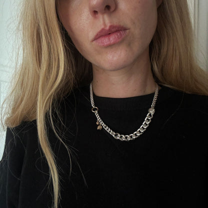 Heavy weight sterling silver curb link chain descending in size. 9ct yellow gold skulls hang off center from links. Handmade in London by Charlie Shires