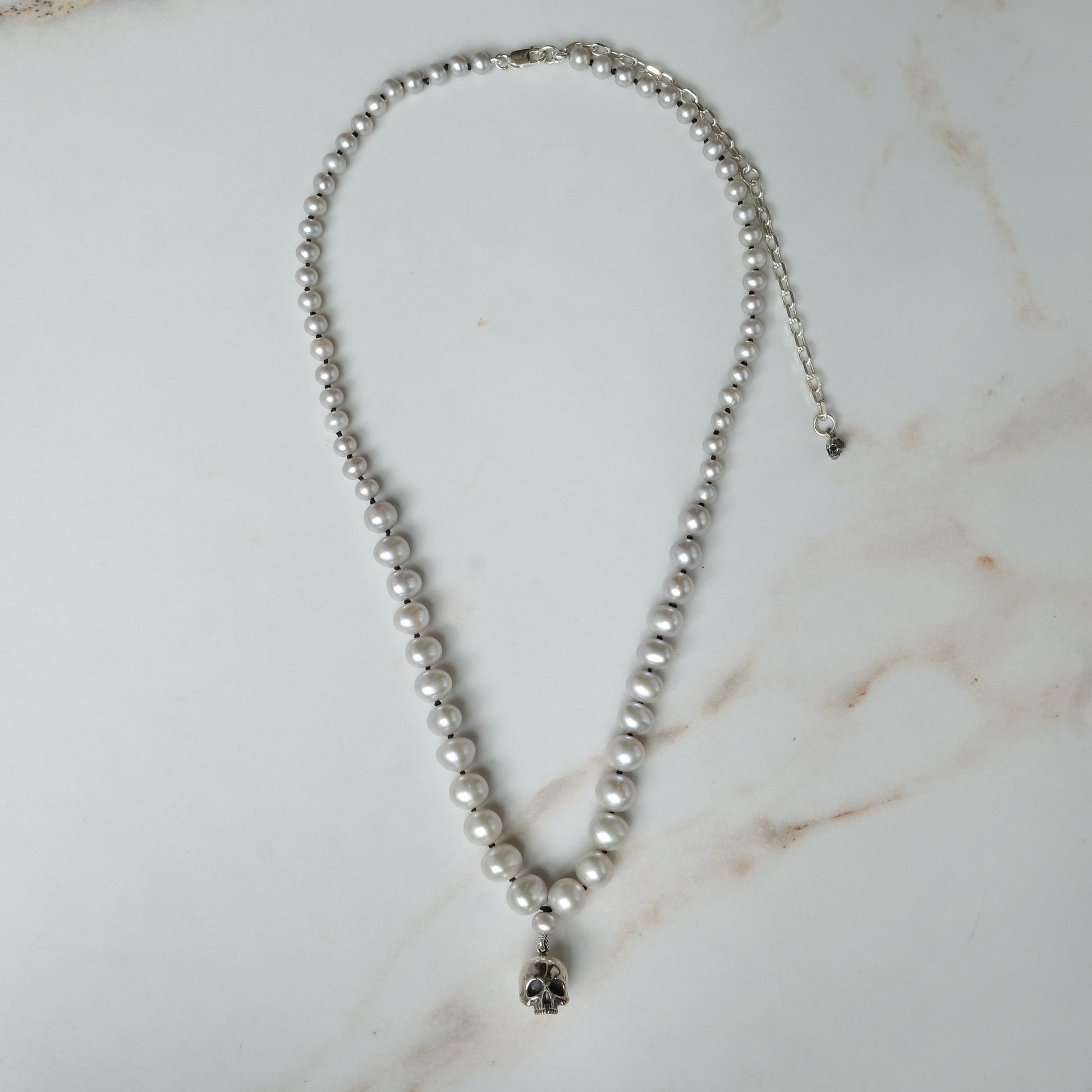 Hand strung grey freshwater pearls with a large sterling silver skull, made by hand in London by Charlie Shires