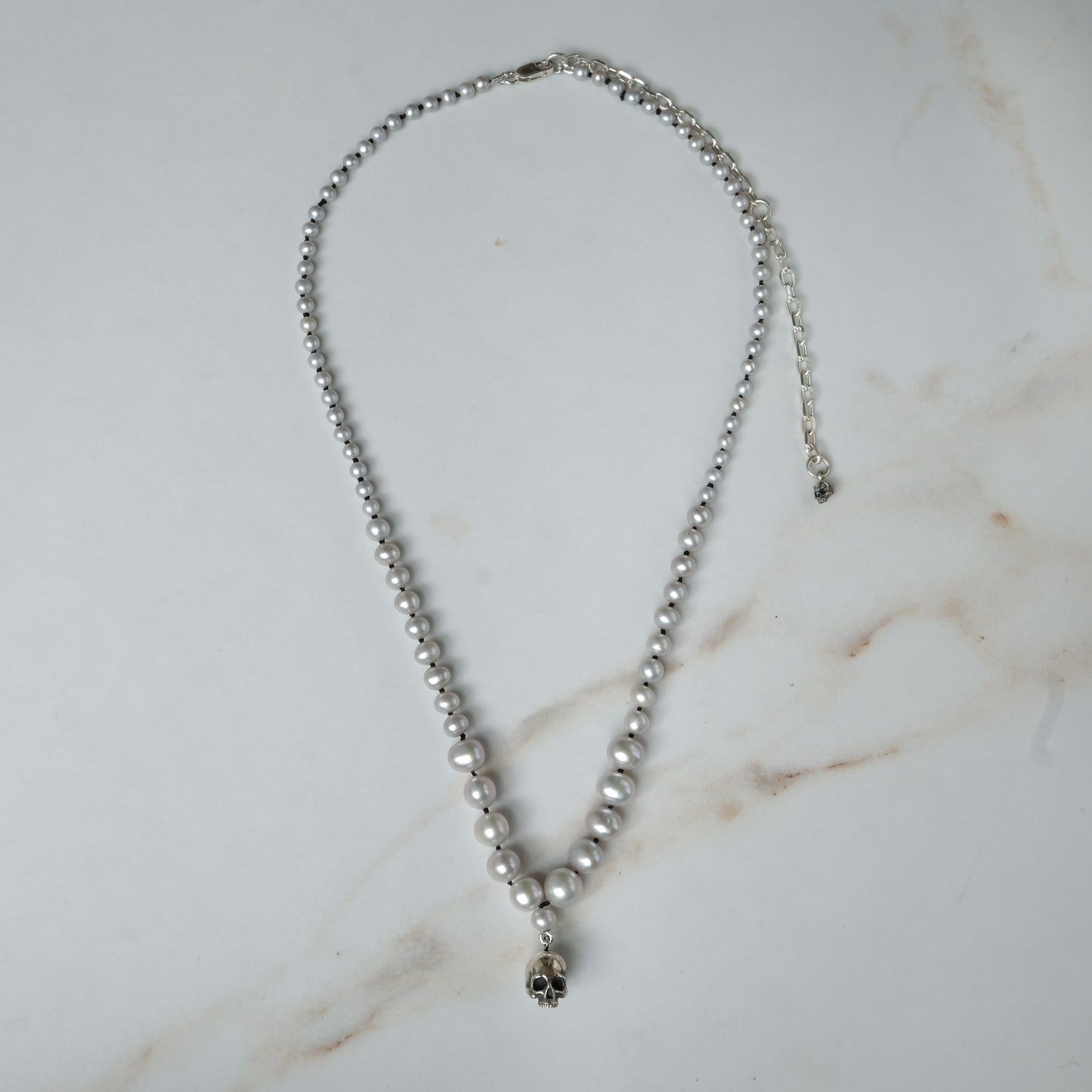 Hand strung grey freshwater pearls with a medium sterling silver skull, made by hand in London by Charlie Shires