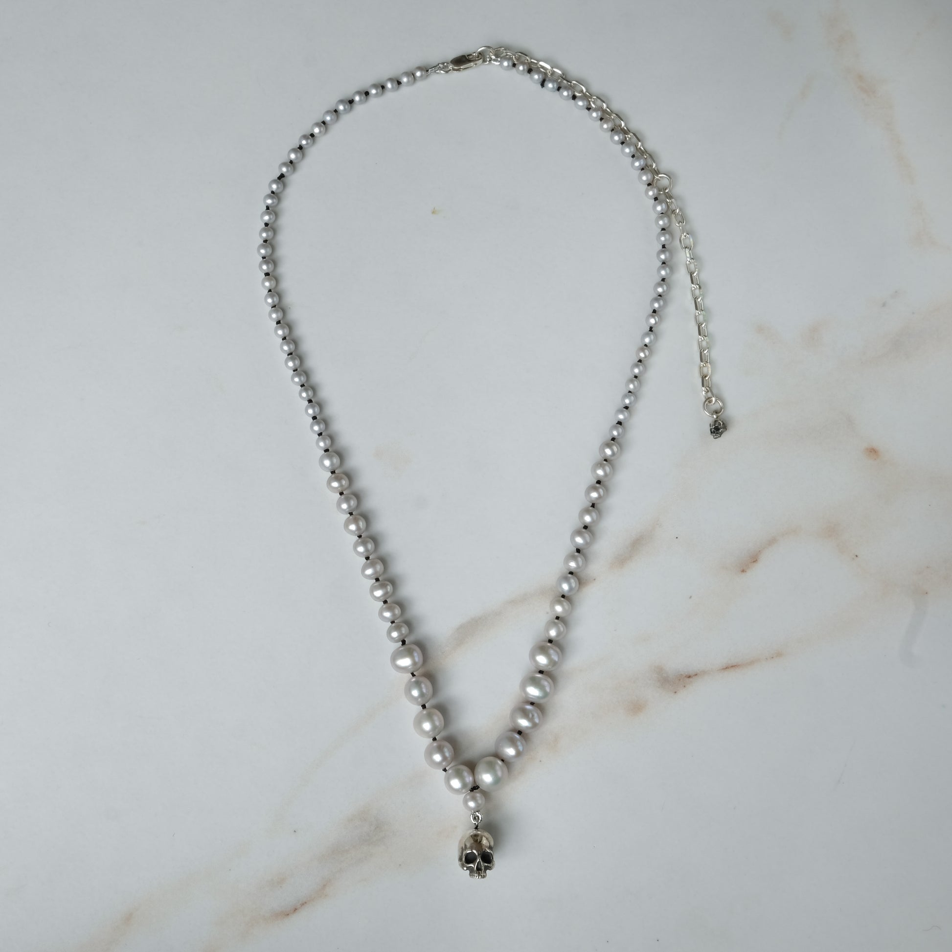 Hand strung grey freshwater pearls with a medium sterling silver skull, made by hand in London by Charlie Shires
