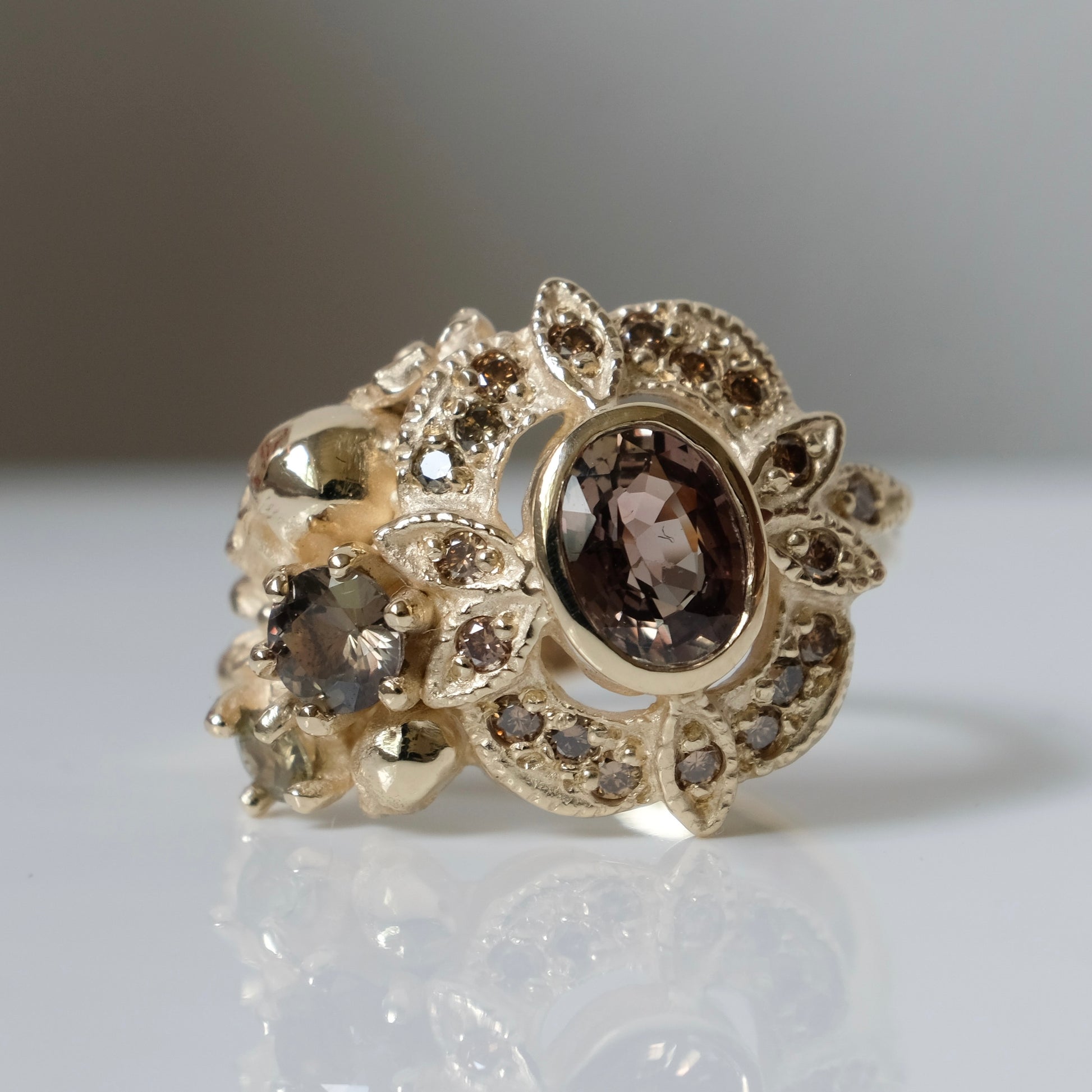 The Helen engagement ring with colour change sapphire, champagne diamond with skulls and flowers made in 9ct yellow gold in London by Charlie Shires