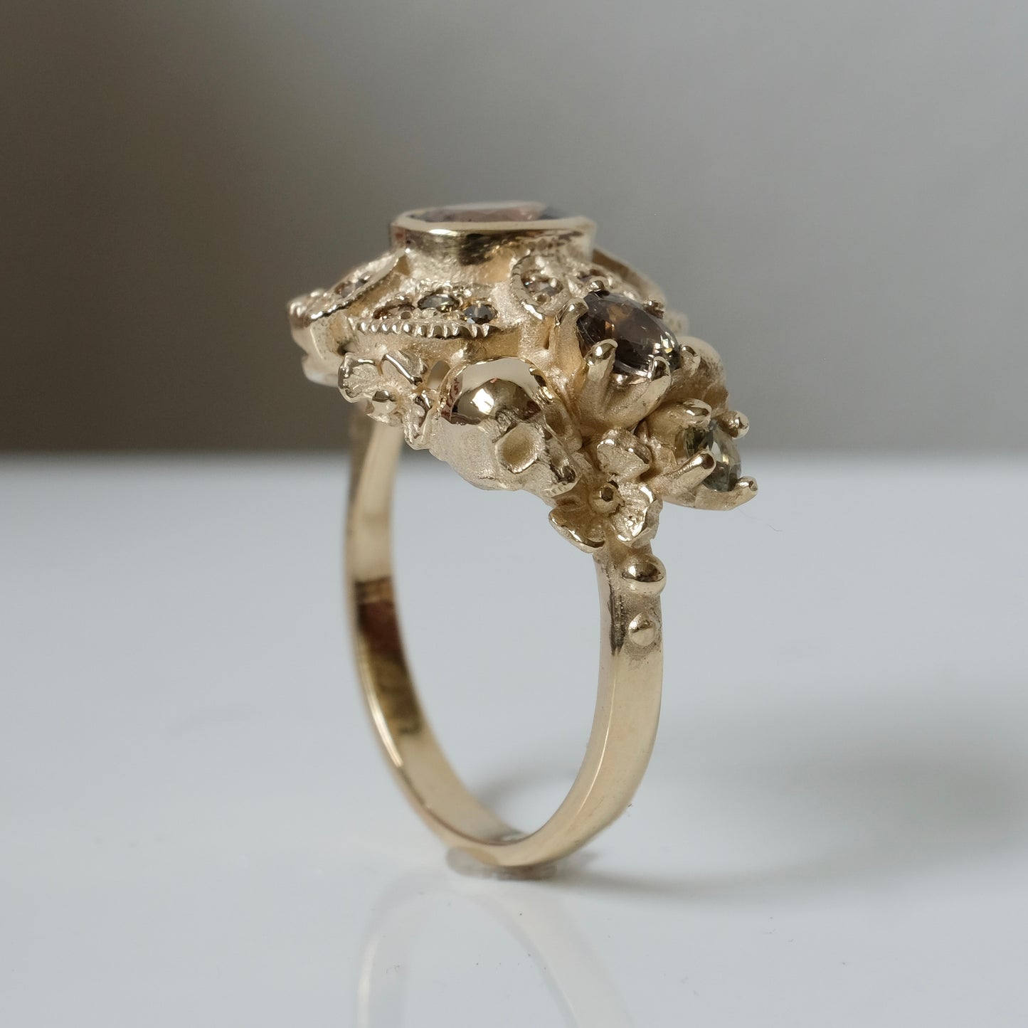 The Helen engagement ring with colour change sapphire, champagne diamond with skulls and flowers made in 9ct yellow gold in London by Charlie Shires
