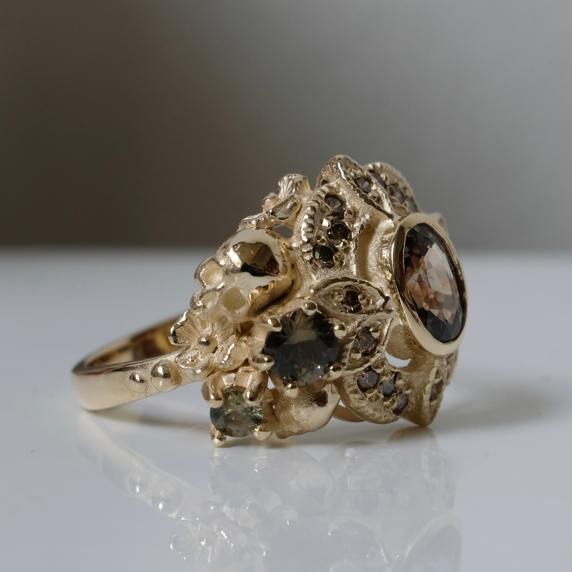 The Helen engagement ring with colour change sapphire, champagne diamond with skulls and flowers made in 9ct yellow gold in London by Charlie Shires