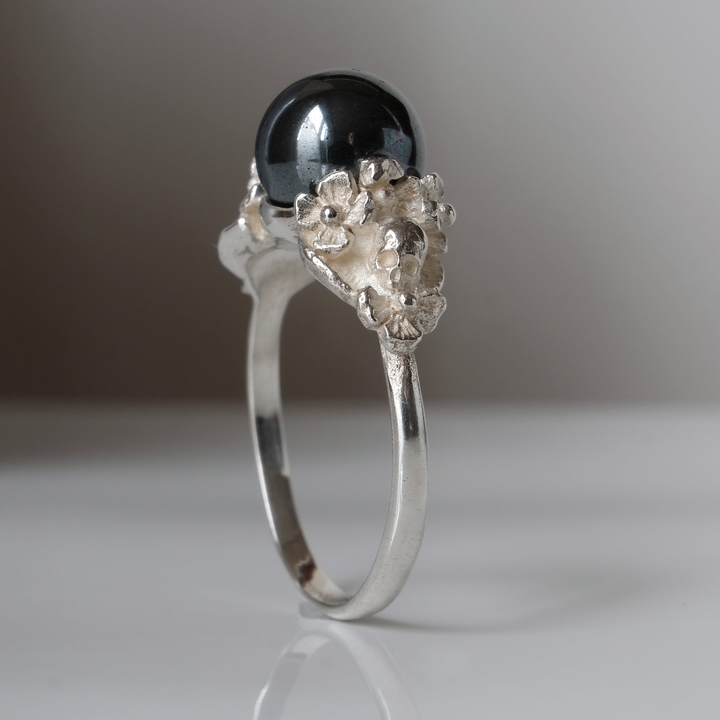 Silver skull and flower hematite ring by Charlie Shires