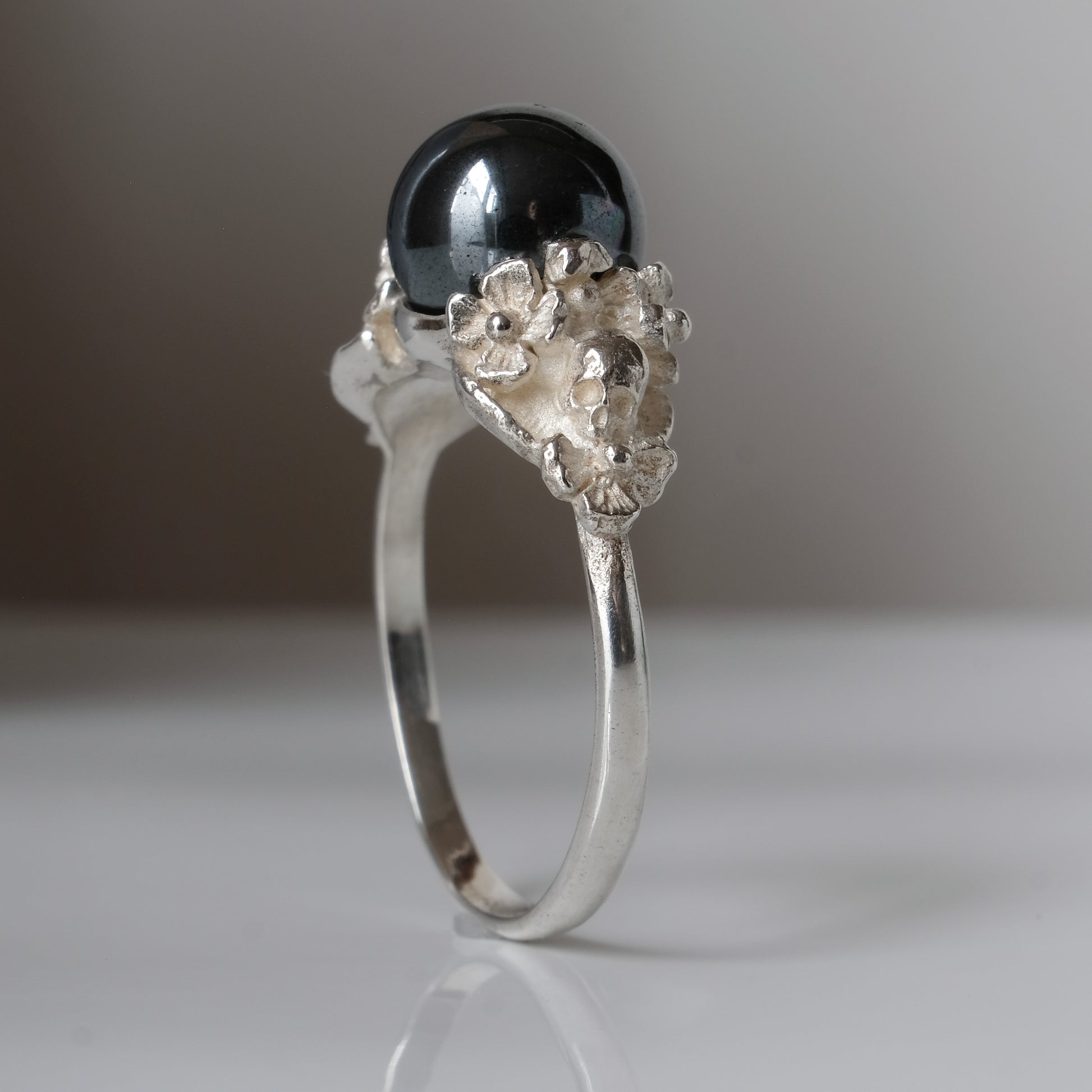Silver skull and flower hematite ring by Charlie Shires