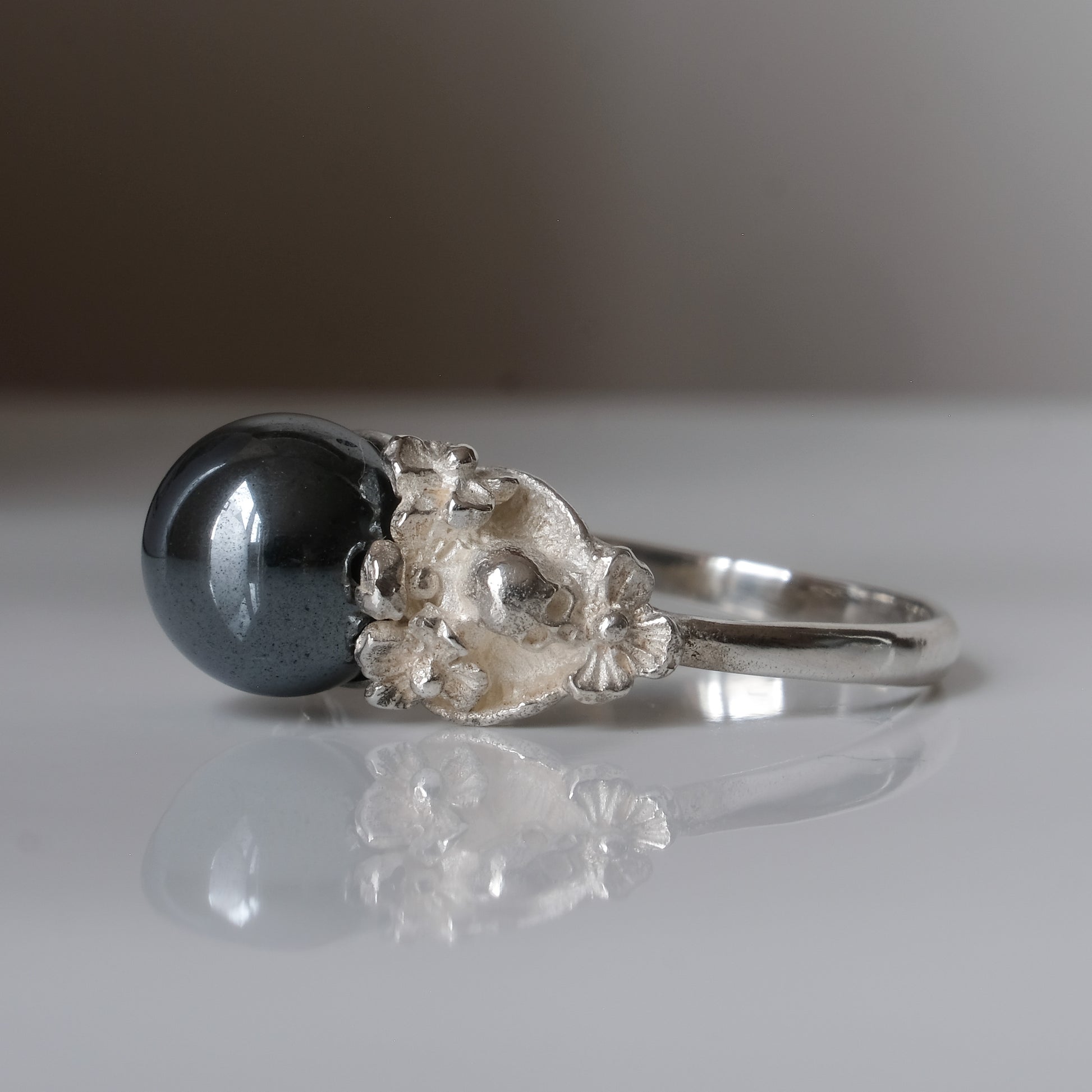 Silver skull and flower hematite ring by Charlie Shires