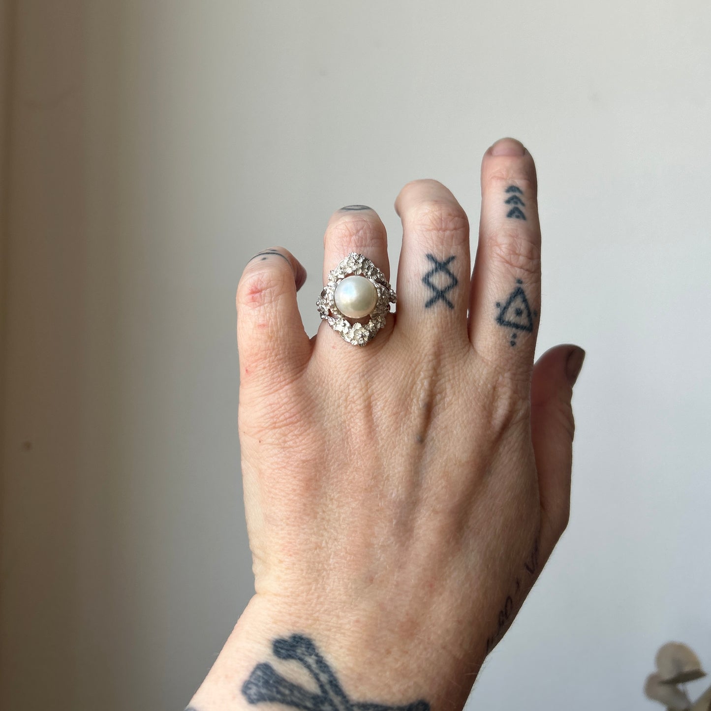Large pearl ring with flower and skull motif down band. made in sterling silver in London by Charlie Shires