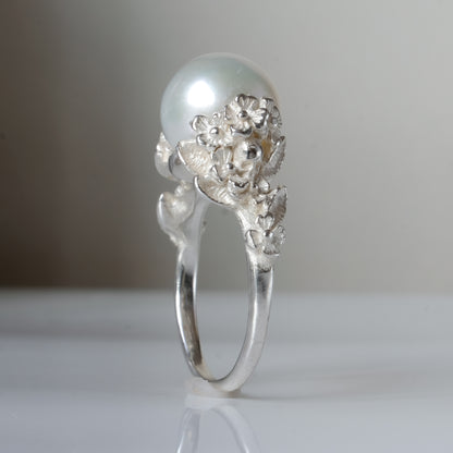Large pearl ring with flower and skull motif down band. made in sterling silver in London by Charlie Shires