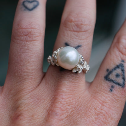 Large pearl ring with flower and skull motif down band. made in sterling silver in London by Charlie Shires