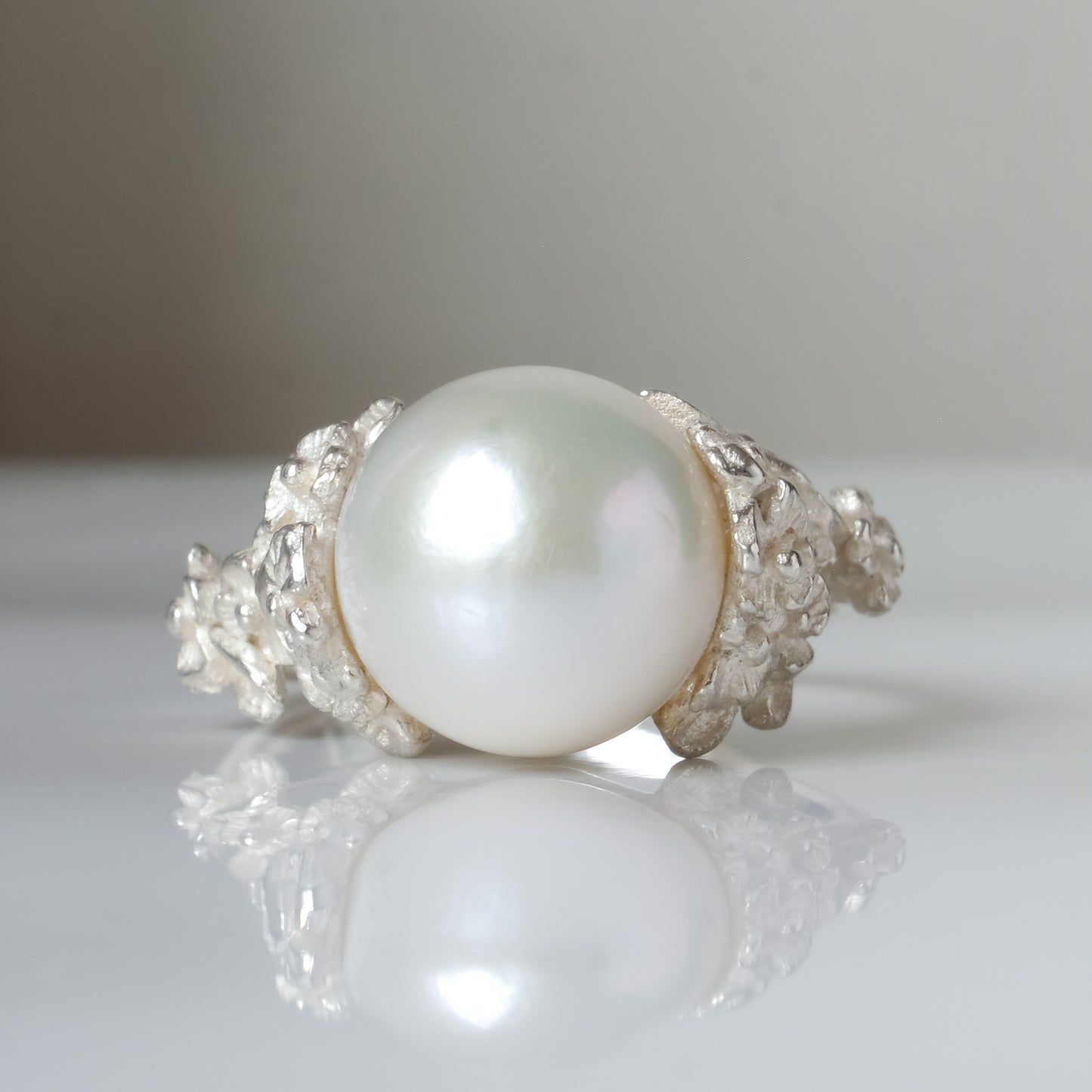Large pearl ring with flower and skull motif down band. made in sterling silver in London by Charlie Shires