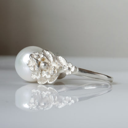 Large pearl ring with flower and skull motif down band. made in sterling silver in London by Charlie Shires