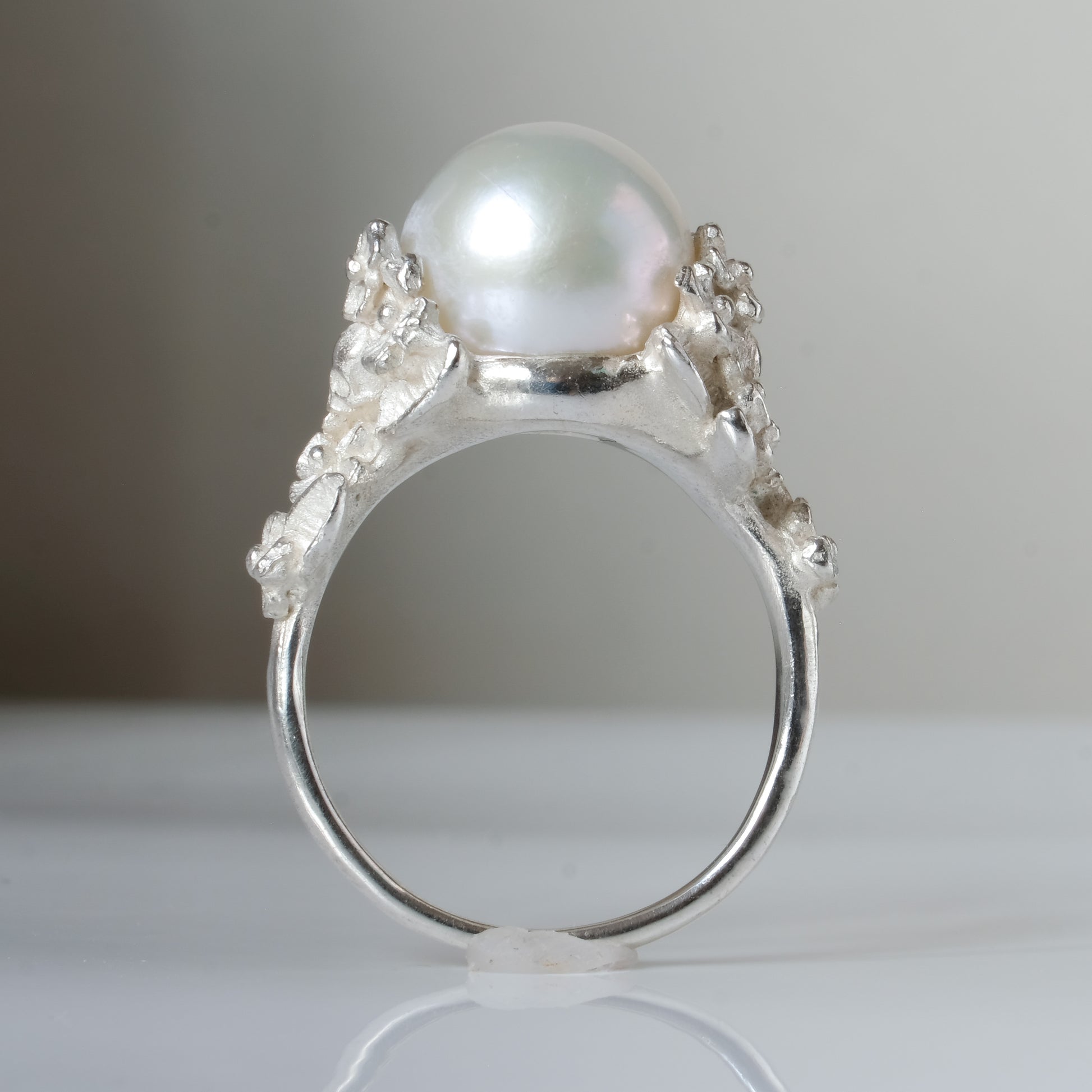 Large pearl ring with flower and skull motif down band. made in sterling silver in London by Charlie Shires