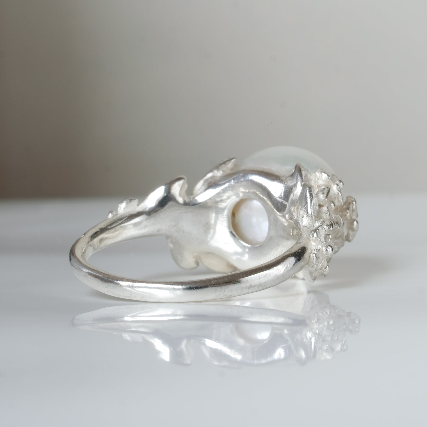 Large pearl ring with flower and skull motif down band. made in sterling silver in London by Charlie Shires