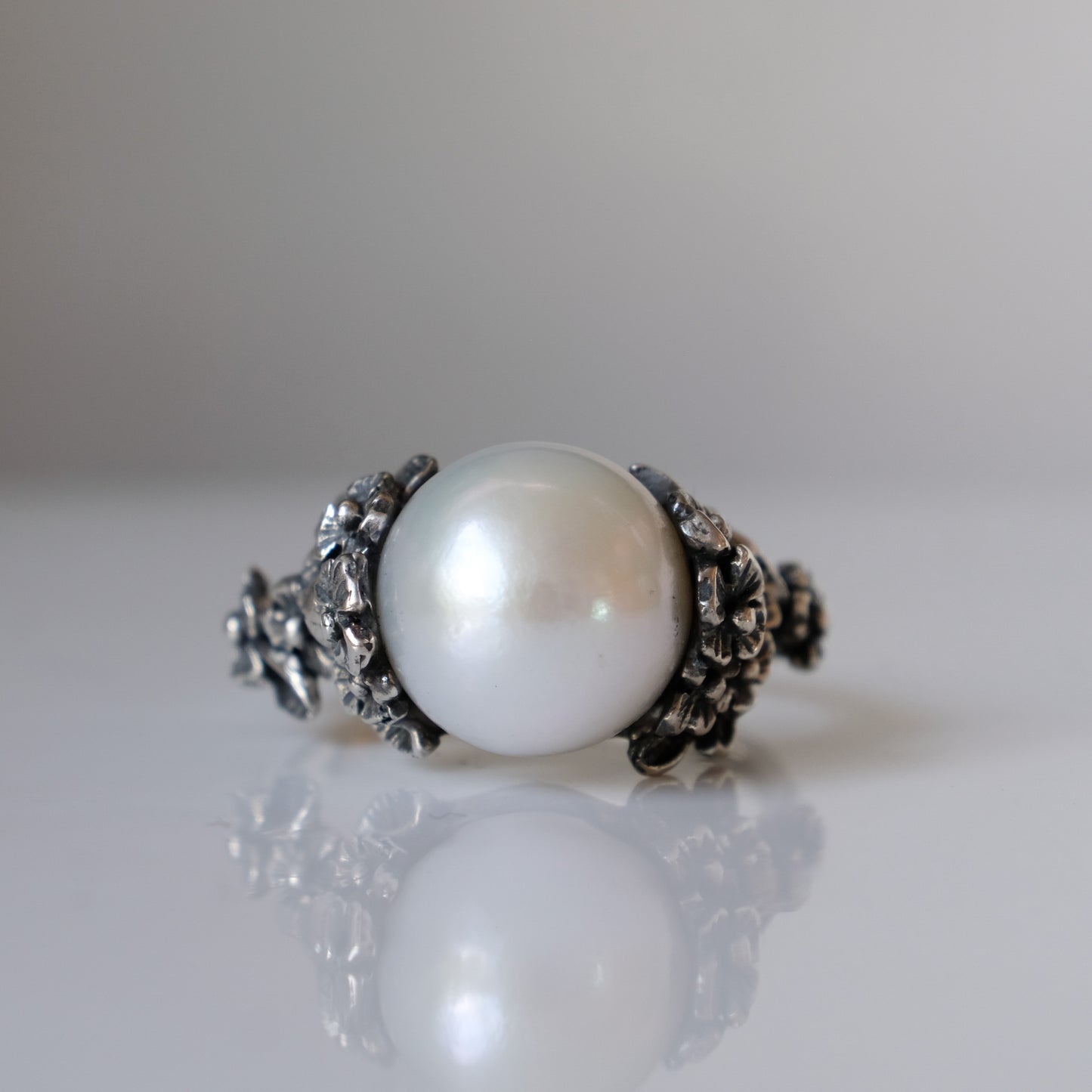 Large pearl ring with flower and skull motif down band. made in sterling silver in London by Charlie Shires