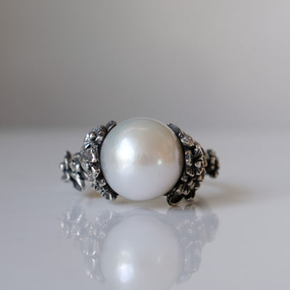 Large pearl ring with flower and skull motif down band. made in sterling silver in London by Charlie Shires