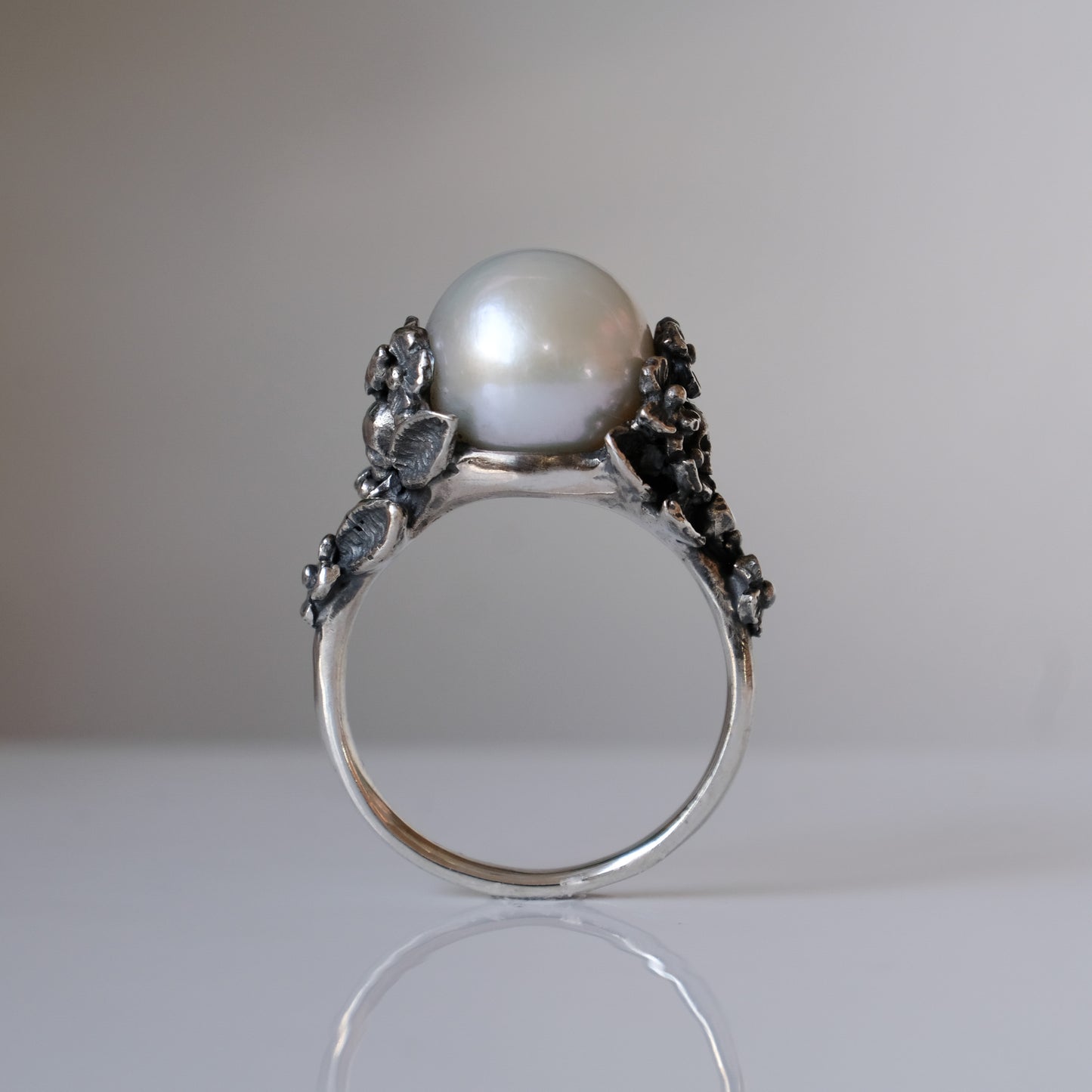 Large pearl ring with flower and skull motif down band. made in sterling silver in London by Charlie Shires