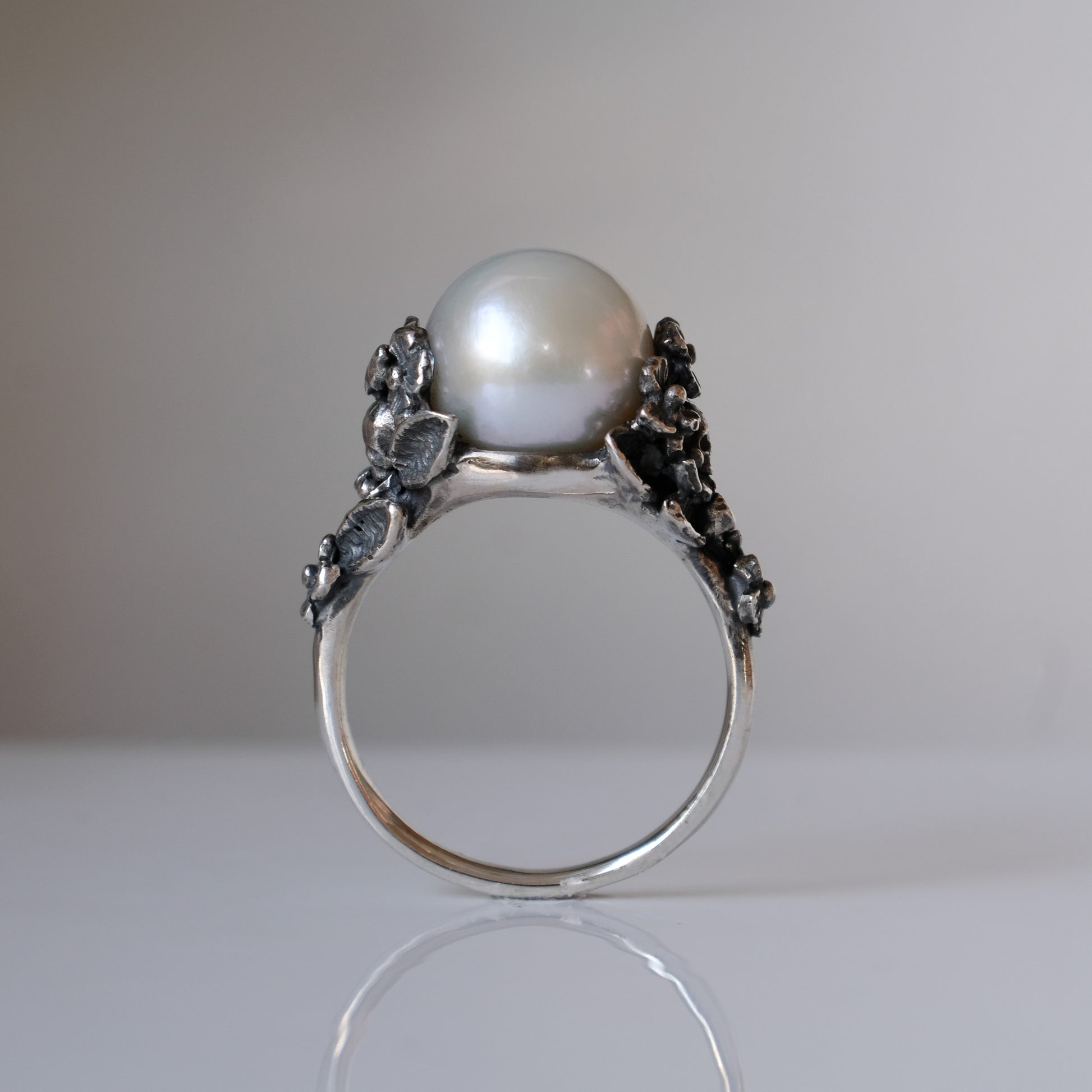 Large pearl ring with flower and skull motif down band. made in sterling silver in London by Charlie Shires