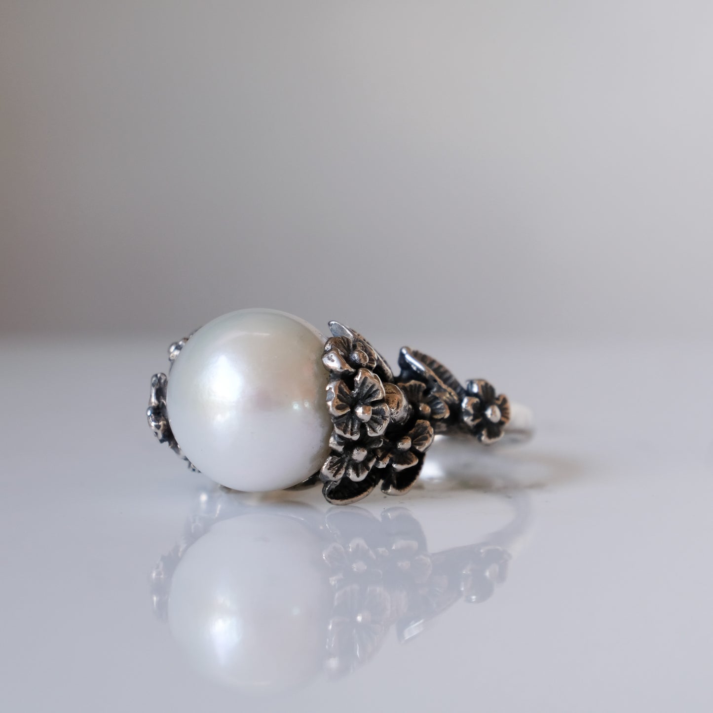 Large pearl ring with flower and skull motif down band. made in sterling silver in London by Charlie Shires