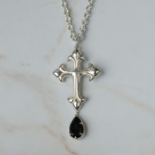 Hand carved crucifix necklace with pear shaped claw set drop black spinel. Made in sterling silver by Charlie Shires in London