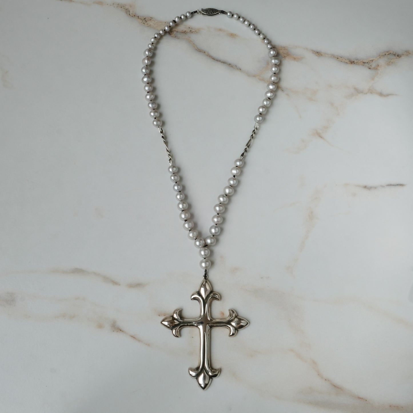 Large crucifix hand strung on a pearl chain. Crucifix is made of Sterling silver by Charlie Shires