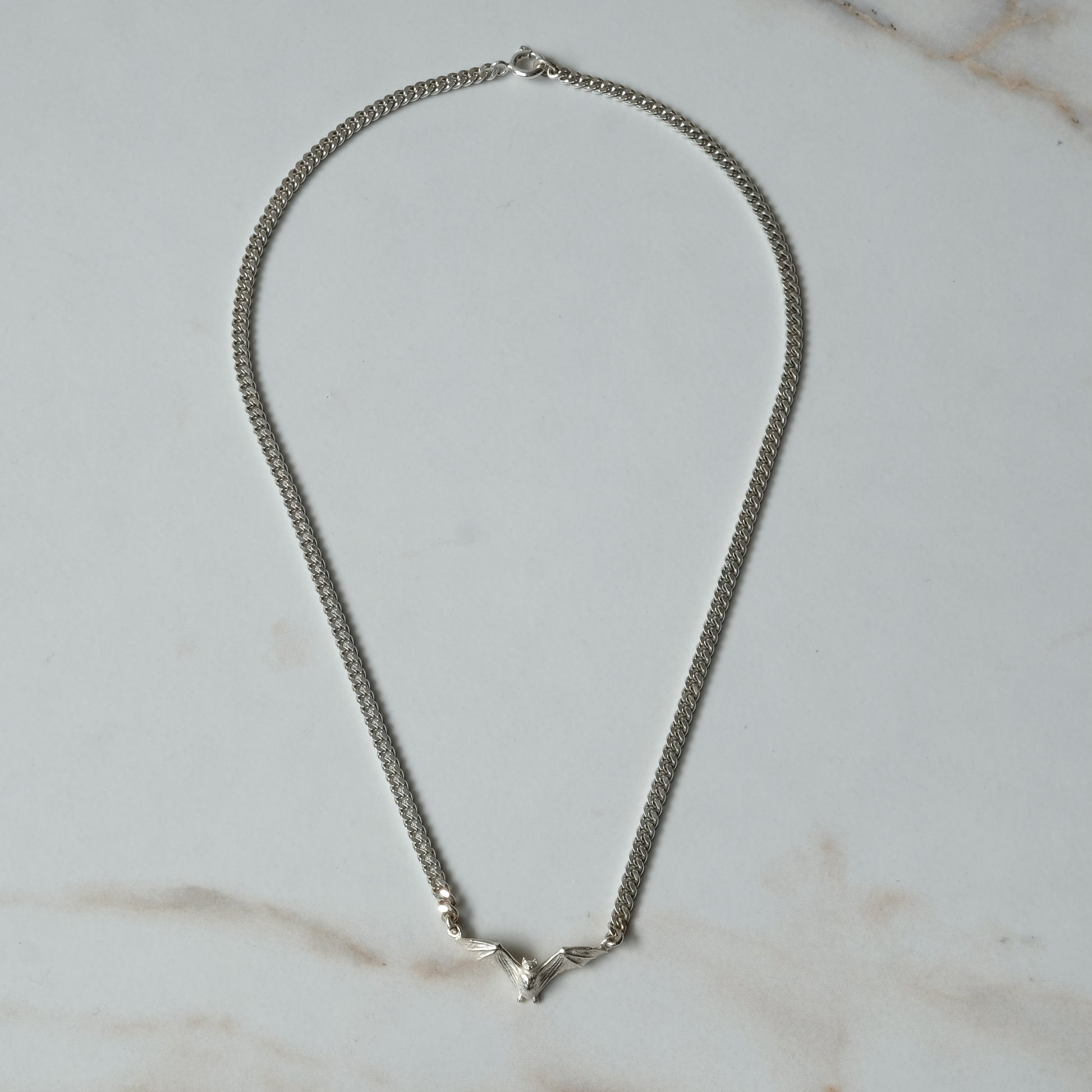 Bat necklace on curb link chain, made in sterling silver by Charlie Shires in London