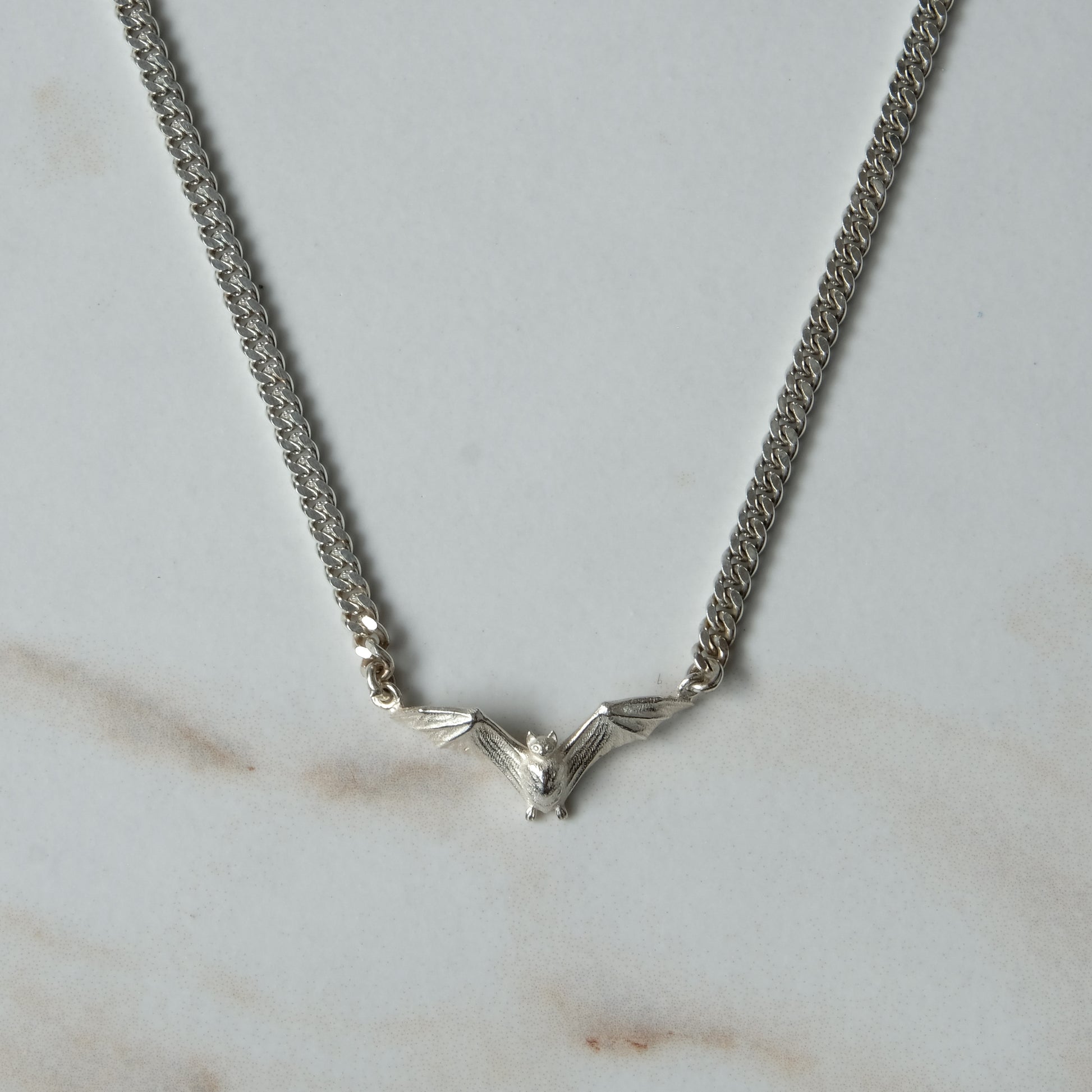 Bat necklace on curb link chain, made in sterling silver by Charlie Shires in London