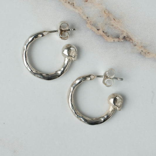 Small hoop earrings with molten detail and skulls at back in sterling silver by Charlie Shires