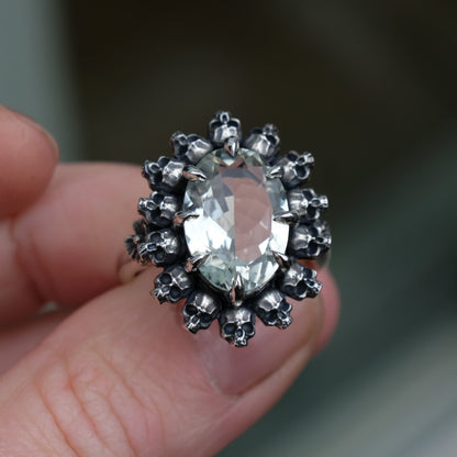 Ring with claw set with mint quartz gemstone and silver skull design  with green background