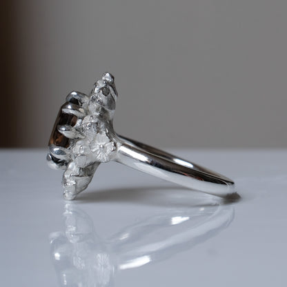 Silver ring with brown smokey quartz gemstone in skull halo design on reflective background handmade in London, UK