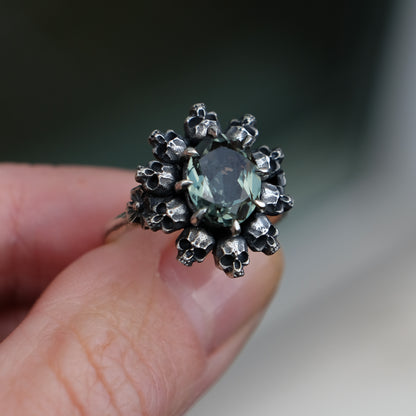 Skull halo ring with synthetic tourmaline stone and flowers on side of band by Charlie Shires