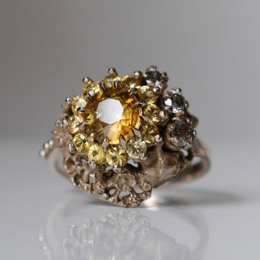 Salacia engagement ring with central Sphene and sapphire halo, salt and pepper diamonds, skulls and flowers. Made in 14t white gold in London by Charlie Shires