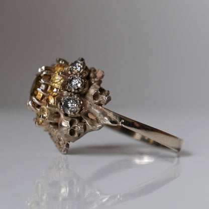 Salacia engagement ring with central Sphene and sapphire halo, salt and pepper diamonds, skulls and flowers. Made in 14ct white gold in London by Charlie Shires