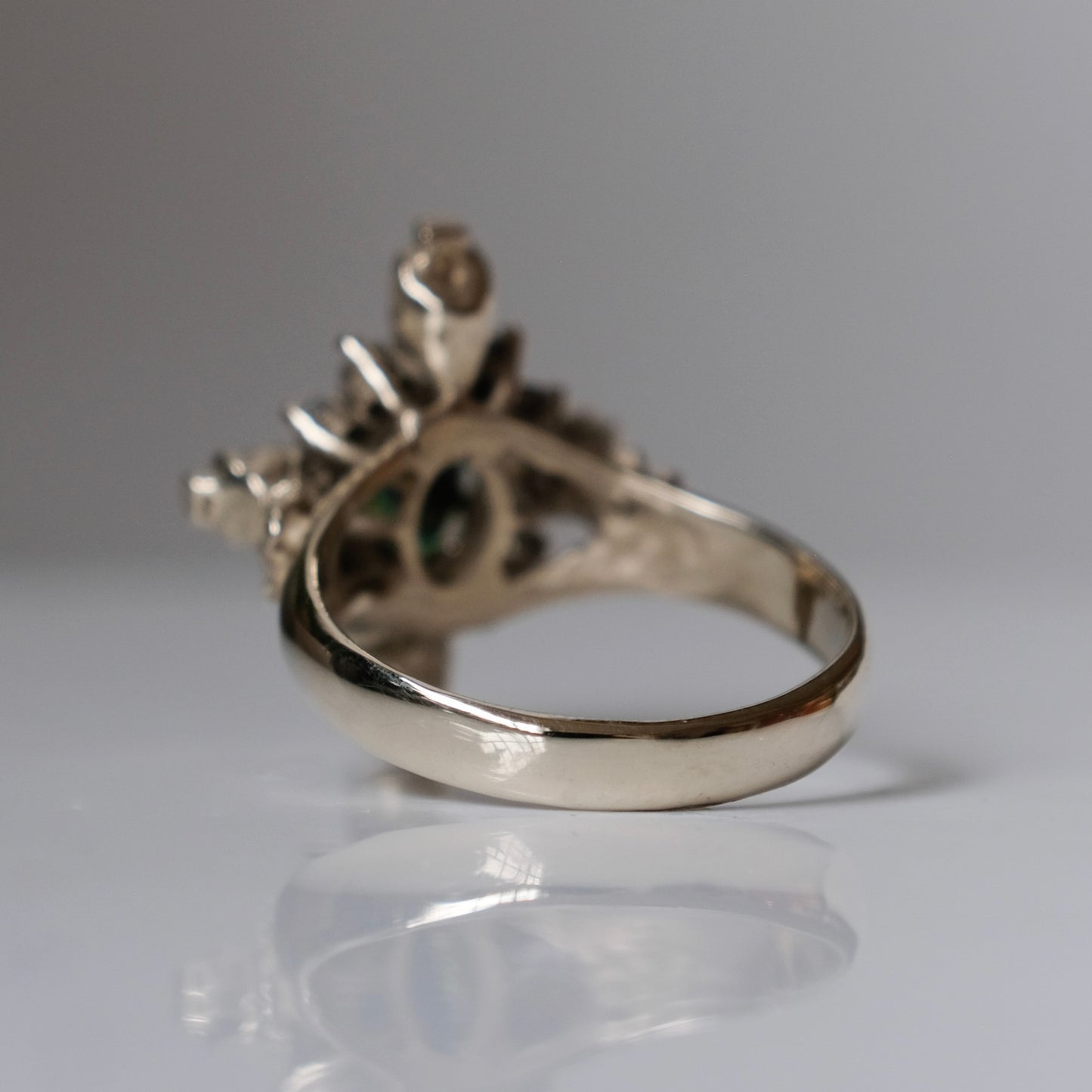 14ct white gold parti sapphire ring with halo of diamonds and skulls. Flowers flank the side of the band. Handmade in London by Charlie Shires