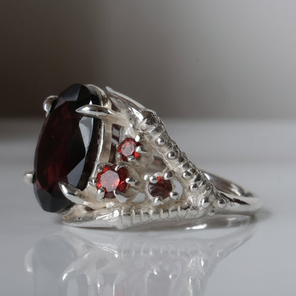 Silver birds talon claw ring with garnet stones by Charlie Shires