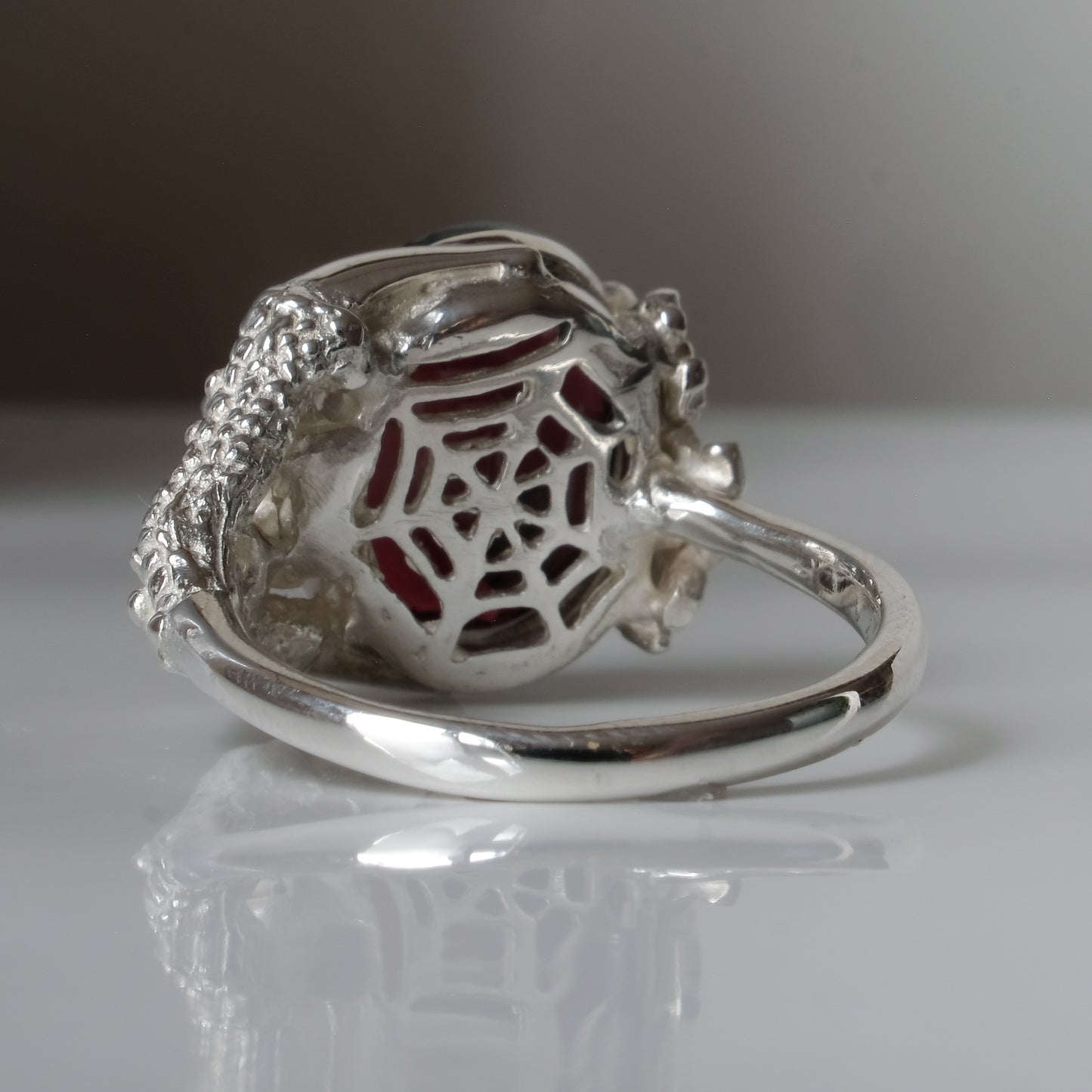 Silver birds talon claw ring with garnet stones by Charlie Shires
