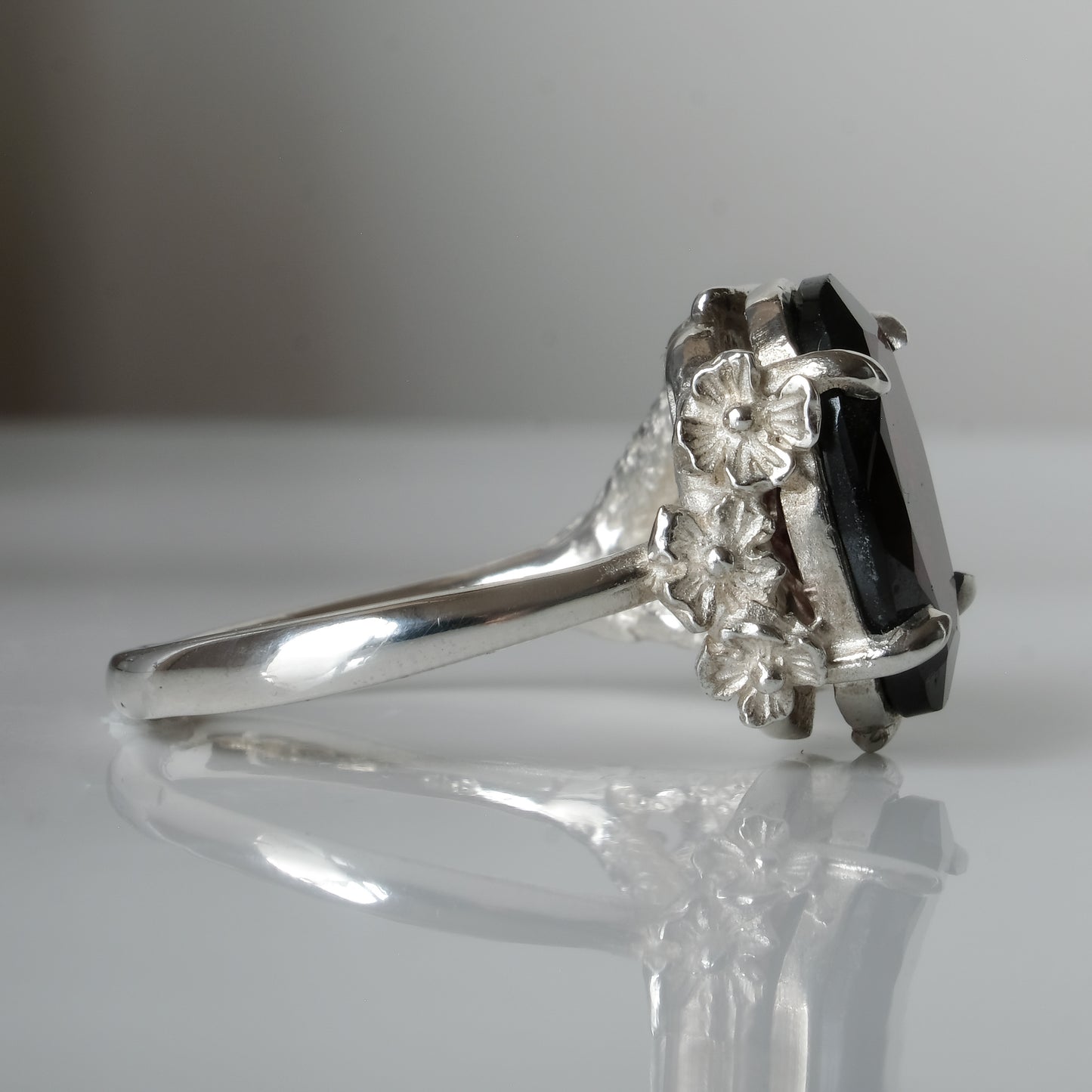 Silver birds talon claw ring with garnet stones by Charlie Shires