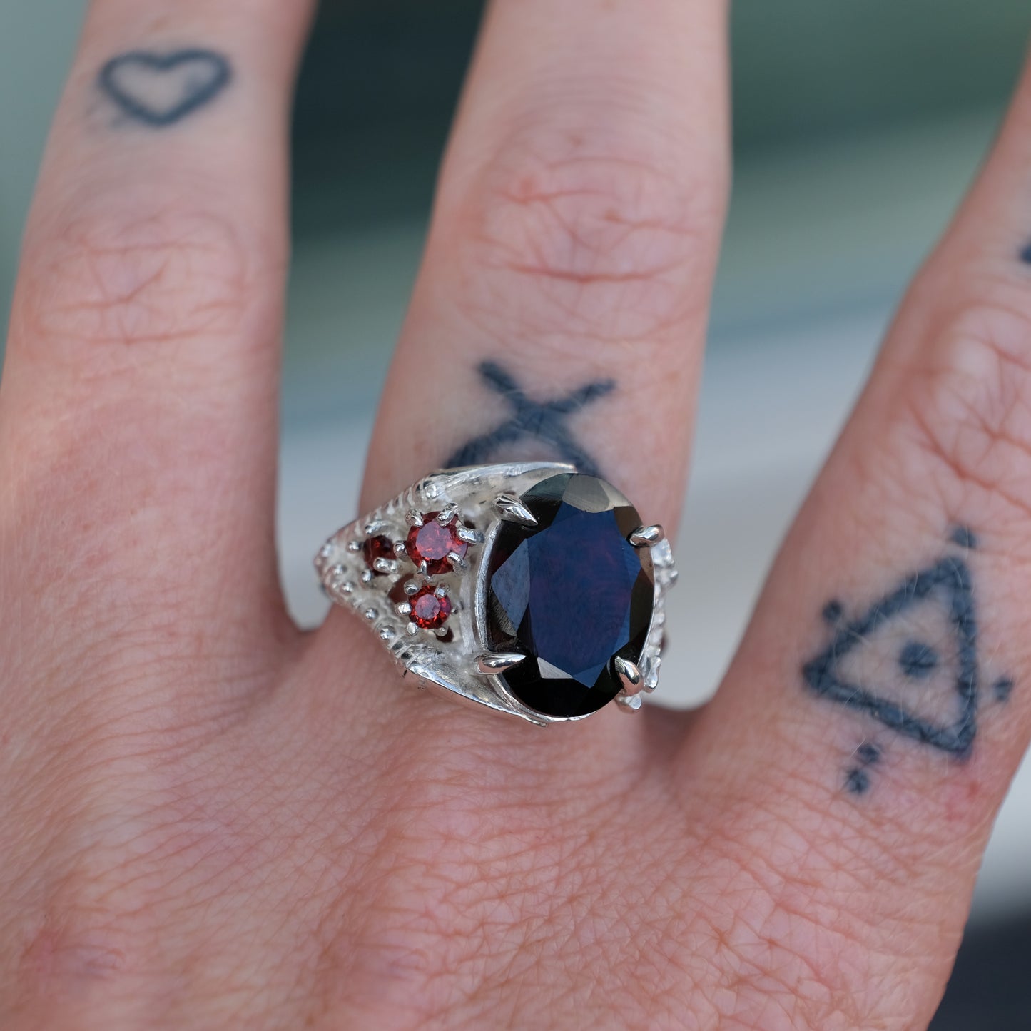 Silver birds talon claw ring with garnet stones by Charlie Shires