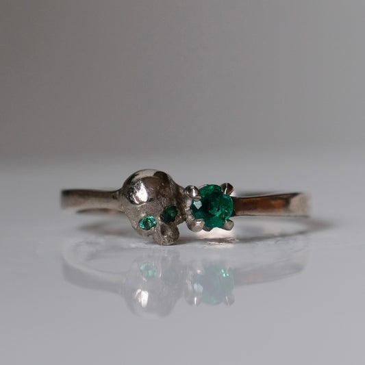 14ct white gold engagement ring with skull and emerald claw set stone. Handmade in London by Charlie Shires