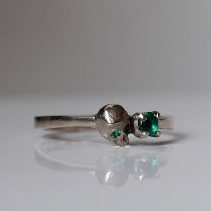 14ct white gold engagement ring with skull and emerald claw set stone. Handmade in London by Charlie Shires