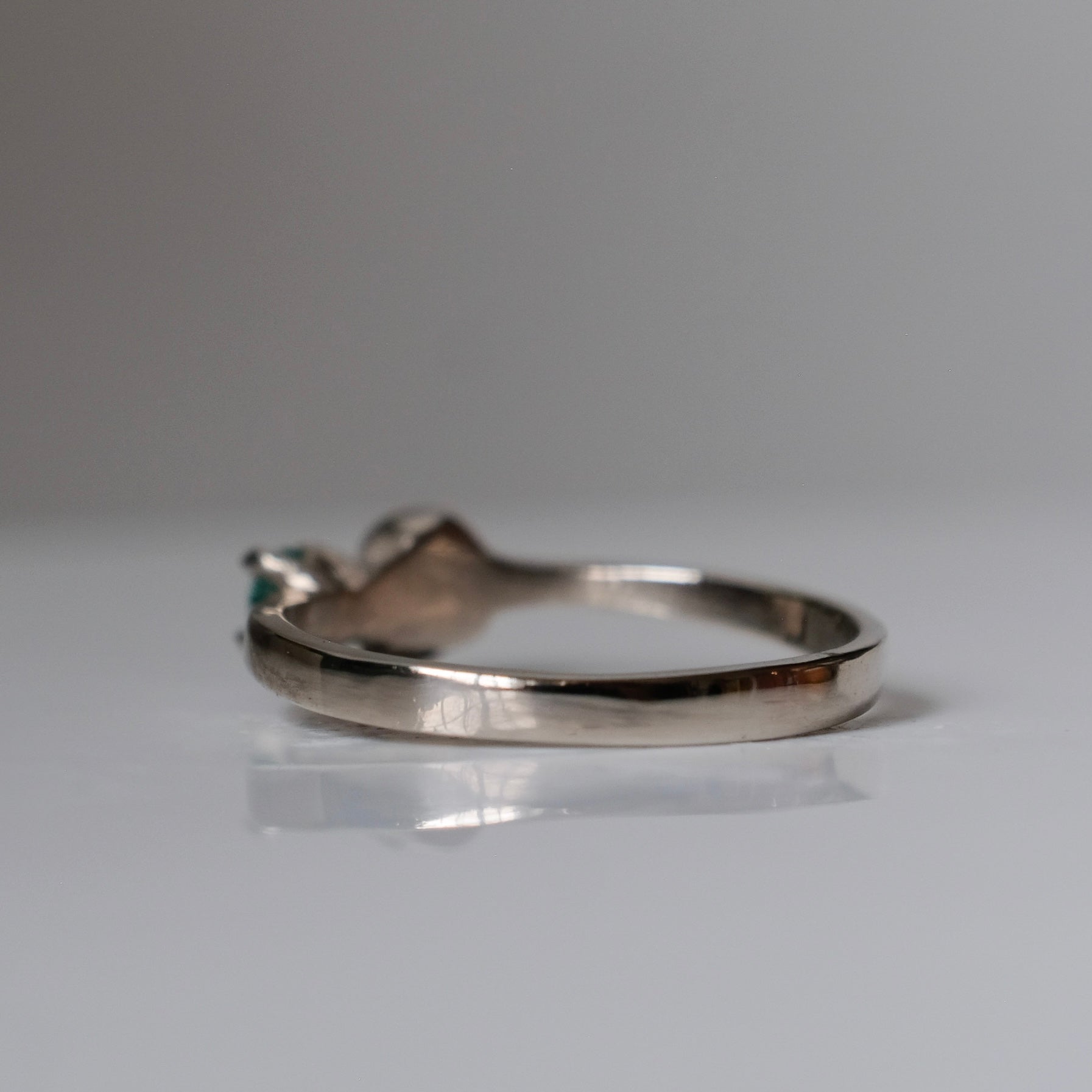 14ct white gold engagement ring with skull and emerald claw set stone. Handmade in London by Charlie Shires