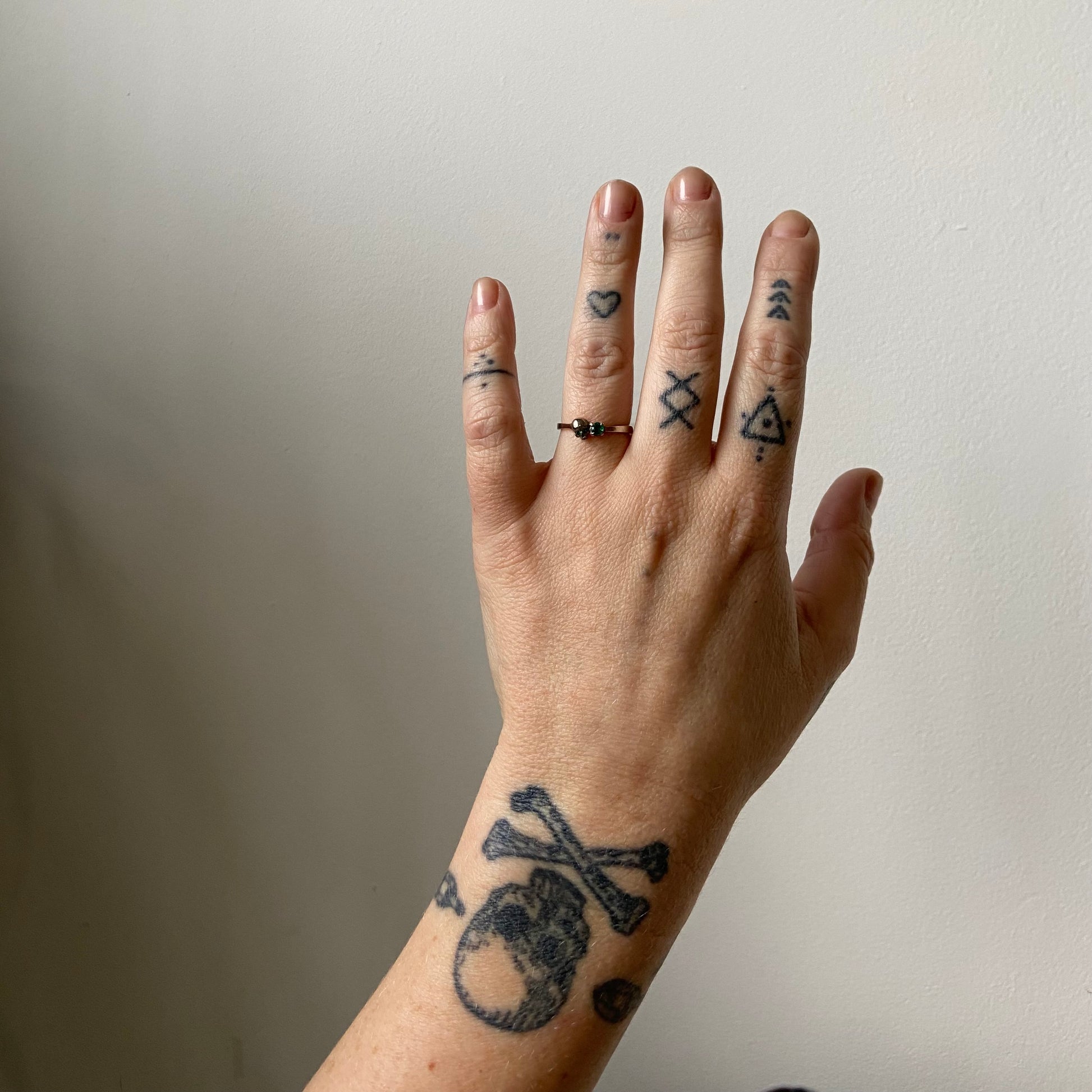 14ct white gold engagement ring with skull and emerald claw set stone. Handmade in London by Charlie Shires