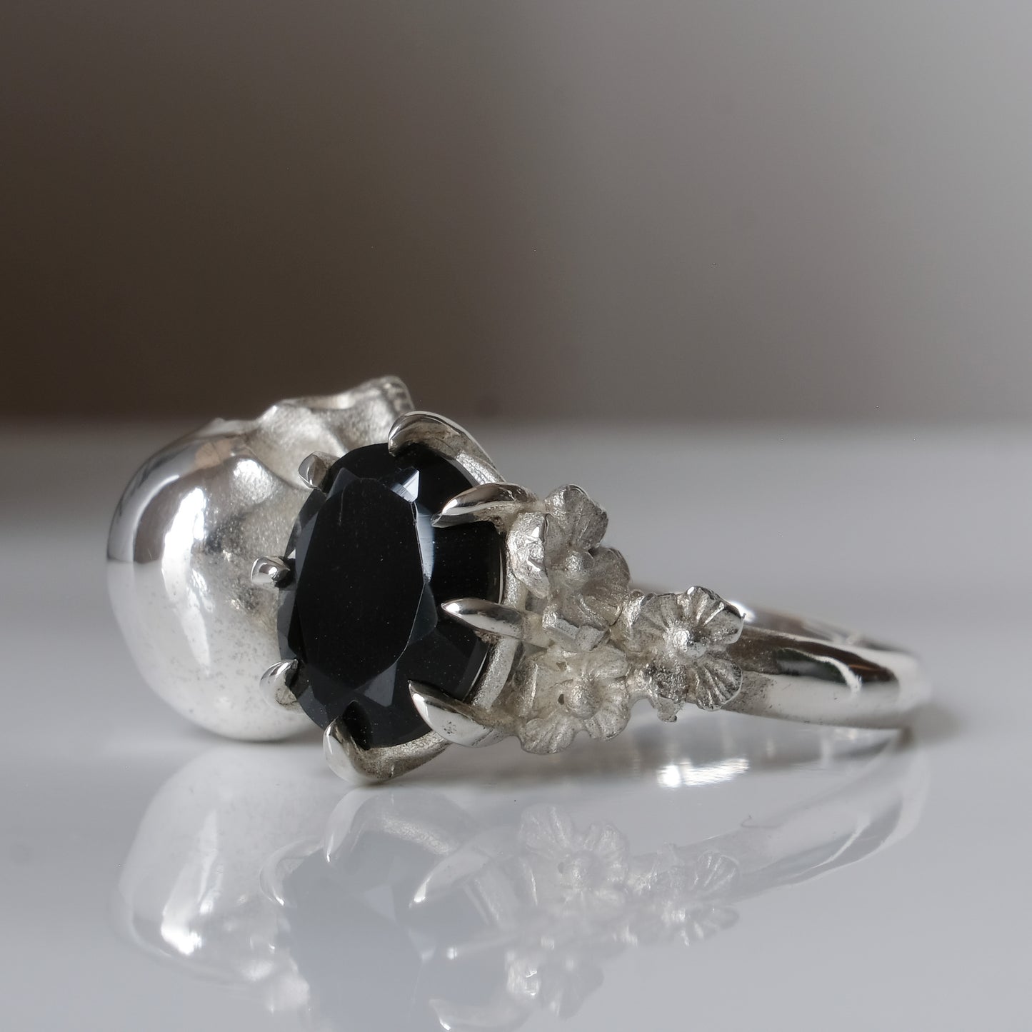 Silver skull and black spinel ring with decorative flowers by Charlie Shires jewellery