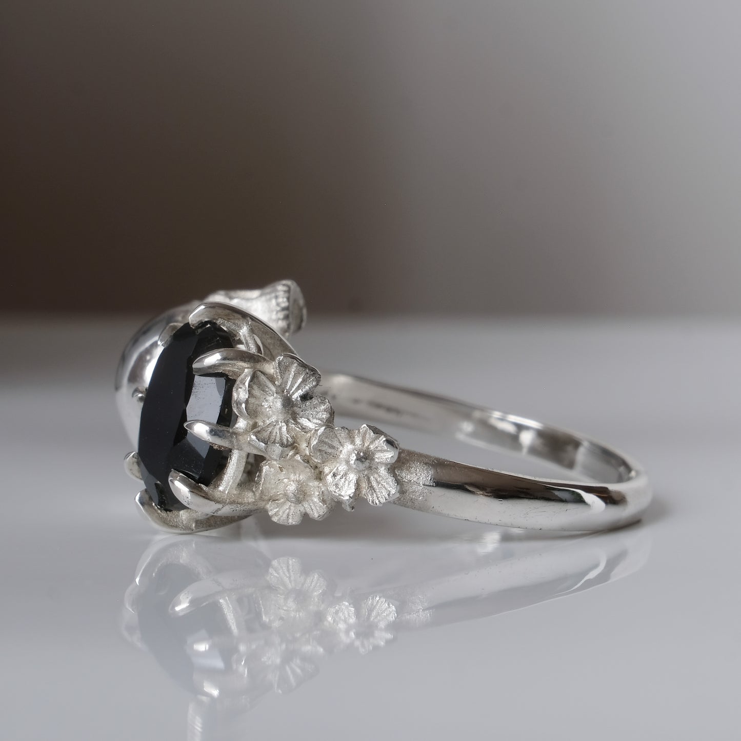 Silver skull and black spinel ring with decorative flowers by Charlie Shires jewellery