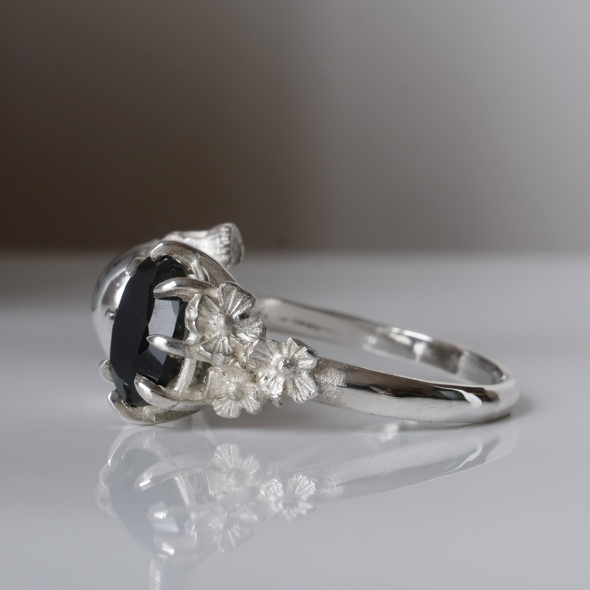 Silver skull and black spinel ring with decorative flowers by Charlie Shires jewellery