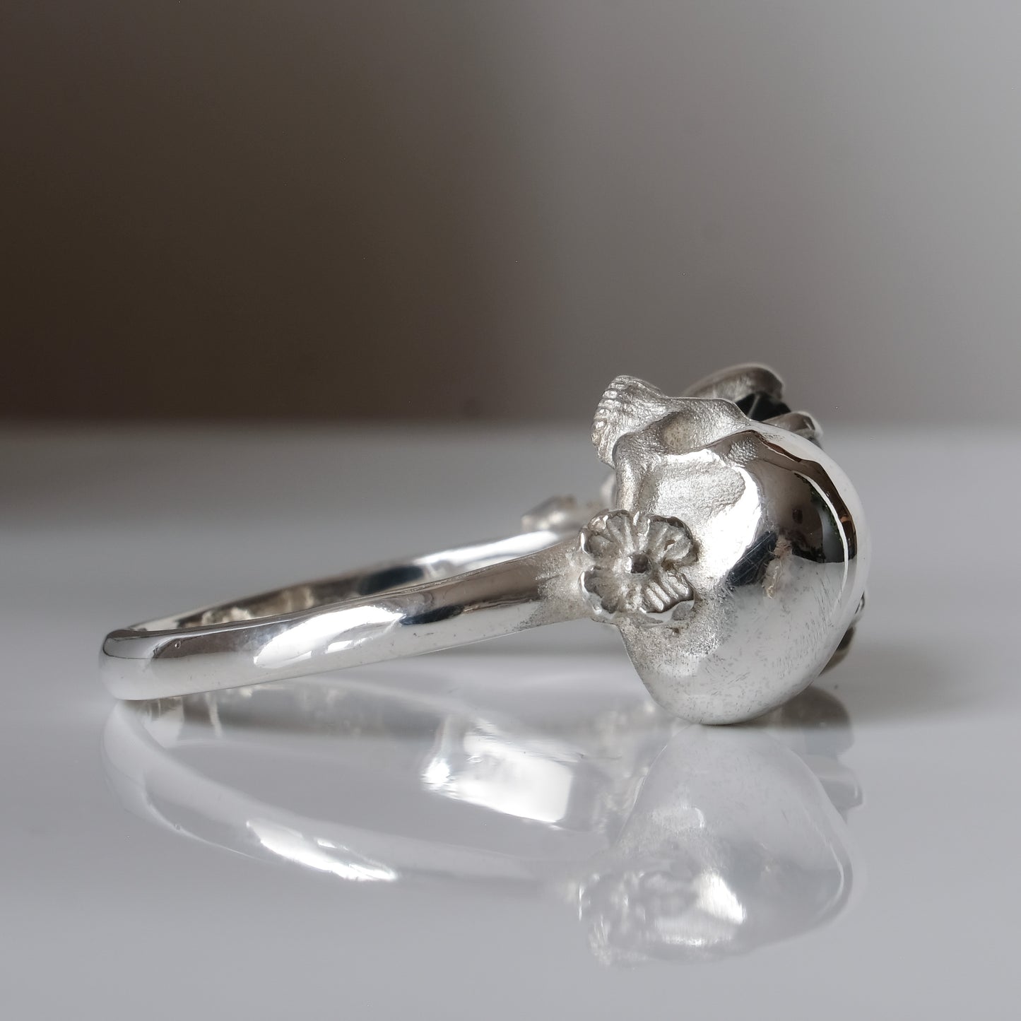 Silver skull and black spinel ring with decorative flowers by Charlie Shires jewellery