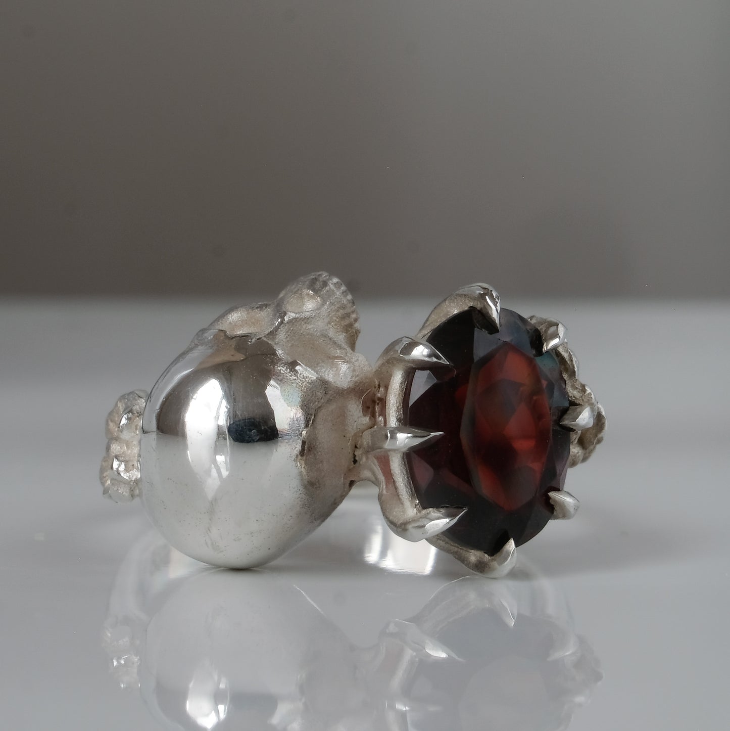 Silver skull and garnet ring with decorative flowers